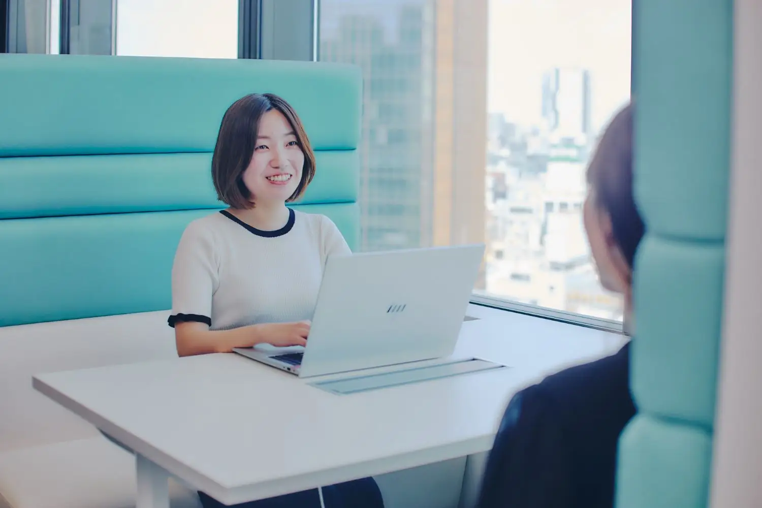 窓際でパソコンを操作している女性